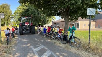 Kinderen op de fiets in straat, met tractor in het midden (copyright Radio2)