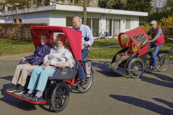 Twee mensen worden vervoerd in een aangepaste fiets